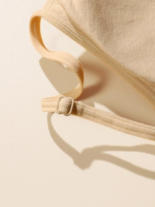 Detail of adjustable straps and fine stitching on a soft beige wireless bralette