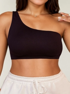 Dettaglio di un crop top nero monospalla che mostra la trama a costine e l'orlo elasticizzato