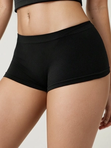 Detail showing the ribbed knit texture and wide waistband of black seamless sports shorts
