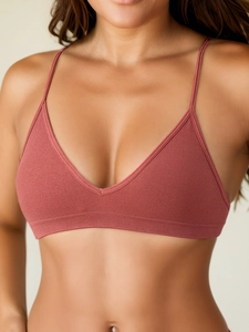 Macro detail of terracotta seamless ribbed yoga bra fabric with thin straps and deep V-neck