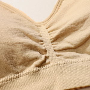 Seamless nude sports bra with ruched center detail and wide ribbed elastic bottom band