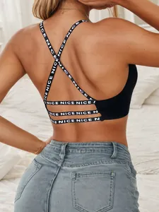 Detail of black sports bra featuring crisscross back straps and NICE lettered elastic bands