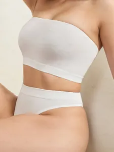 Détail d'un crop top blanc côtelé sans bretelles et d'un string assorti à taille haute