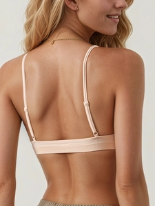 Detail of light pink seamless ribbed bra with adjustable spaghetti straps and knit texture
