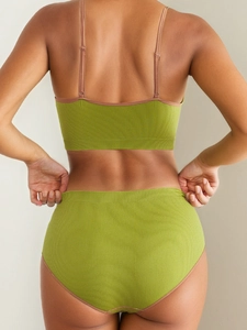 Detail view of the seamless green ribbed bralette set showing the strappy back design