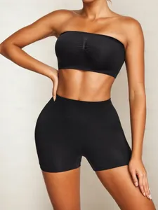 Detail of black seamless sports set featuring high-waisted shorts and ruched tube top