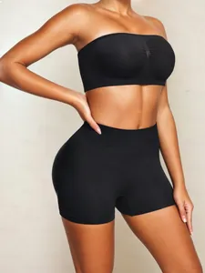 Detail view of seamless black two-piece yoga set with high waist compression shorts