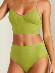 Detailed close-up of green ribbed knit bra and high-waist panty set with elastic texture