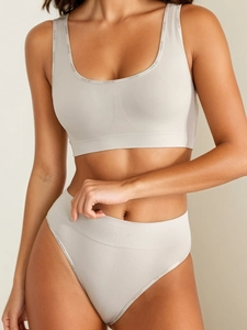 Detail von nahtlosem Sport-BH und High-Waist-Slip mit LEISURE-Schriftzug in Beige