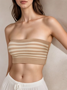 Detail of a seamless strapless beige striped ribbed knit bandeau with elastic hem