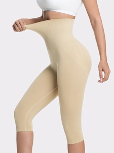 Close-up showing the high elasticity of seamless high-waisted shaper shorts in beige
