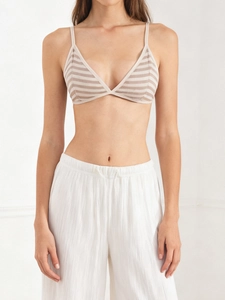 Close-up of a striped triangle bralette paired with white pleated linen trousers
