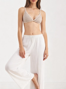 Detail of striped wireless bra and high-waisted pleated trousers in a lounge set