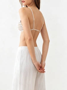Detailed back view of a striped triangle bralette with thin straps and pleated trousers