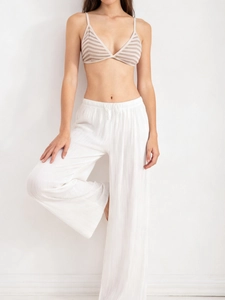 Detail of high-waist white wide-leg trousers with drawstring and soft textured fabric