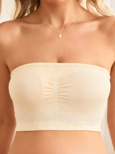 Close-up of beige strapless nursing bra with elastic ruched center and ribbed edges