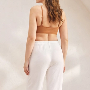 Reggiseno senza cuciture taglie forti da donna con top marrone e pantaloni bianchi a vita alta