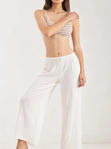 Detail of white wide-leg trousers with drawstring waist and textured fabric