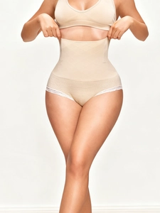 Detail of high-waisted shaping underwear in beige with lace trim and ribbed tummy control