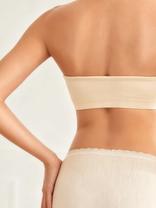 Detail of seamless strapless nursing bra and lace-trim briefs in beige for pregnancy