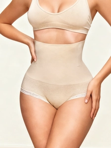 Detail of high-waisted shaping pants featuring lace trim and diamond mesh weave texture