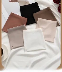 Flat lay of seamless ribbed ice silk panties in six neutral colors on white silk fabric