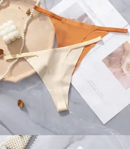 Detailed view of seamless thin-strap thongs in caramel and cream on aesthetic background