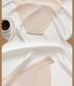 Detail shot of seamless nude ice silk fabric with laser-cut edges on white satin background