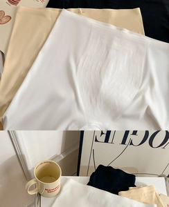 Close-up of seamless high-waist slimming shorts in white, beige, and black elastic fabric