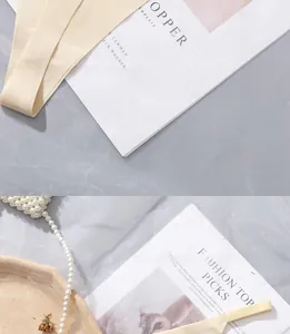 Macro detail of seamless ice silk fabric strap in beige on a marble texture background