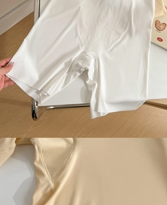 Detail of high-waisted seamless shaping shorts with elastic waistband in white and beige