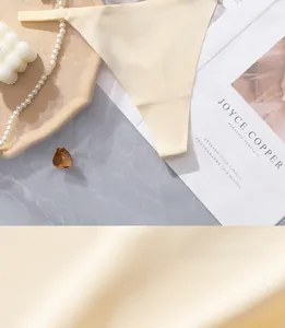 Macro detail of seamless ice silk fabric and thin strap on beige low waist panties