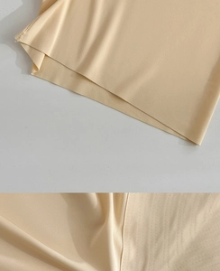 Detail view of seamless beige ice silk fabric with smooth texture and laser-cut edges