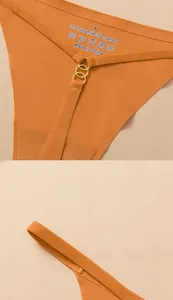 Detail of orange seamless thong with fine straps, gold metal rings and fabric labels