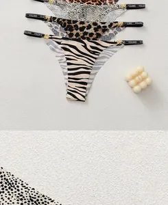 Detailed close-up of leopard and zebra print panties with gold ring accents and lettering