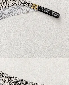 Detail of leopard print fabric with gold metal rings and branded elastic strap decoration
