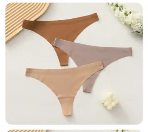Three-pack seamless microfiber thongs in earth tones on a decorative wooden tray