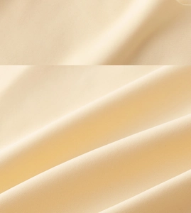 Dettaglio del tessuto beige senza cuciture con trama traspirante e drappeggio morbido