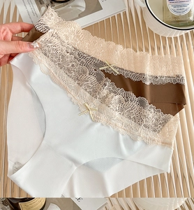 Dettaglio di slip in cotone a coste con elegante bordo in pizzo beige e un fiocchetto