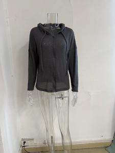 Close-up of dark grey waffle knit fabric texture on a drawstring hooded jacket