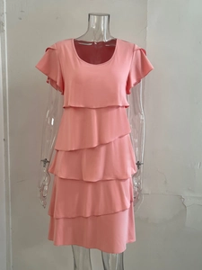 Detailed view of coral pink tiered cake dress with five layered ruffles and flutter sleeves
