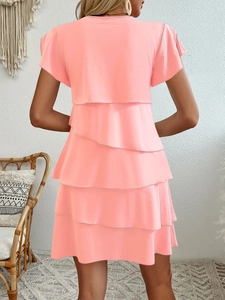 Back view of a tiered pink summer dress with ruffle sleeves on a minimalist background