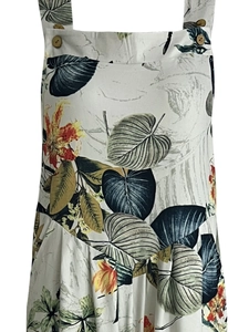 Detail view of tropical leaf print dress featuring wooden decorative buttons on shoulder straps