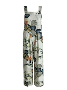 Detail of tropical plant print on women's wide-leg jumpsuit with decorative buttons