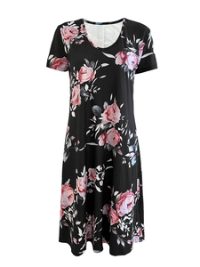 Dettaglio di un abito ampio a linea A con stampe di rose rosa su tessuto nero e scollo a V casual