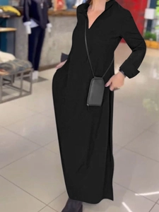 Detalle de vestido negro de manga larga con cuello en V y elegante abertura lateral abajo