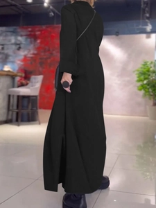 Detalle del vestido largo negro de manga larga con abertura lateral y acabado elegante