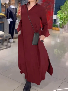 Detalle de vestido largo rojo oscuro con cuello camisero, manga larga y abertura lateral