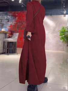 Detalle del vestido largo granate con mangas largas, aberturas laterales y puños doblados