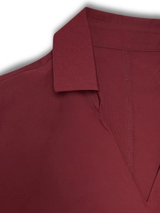 Detalle del vestido burdeos con cuello polo y diseño de malla transparente en escote V